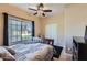 Cozy bedroom featuring a ceiling fan, tiled floors, and a large window with natural light at 2801 N Litchfield Rd # 65, Goodyear, AZ 85395