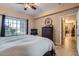 Bedroom featuring a large window, ceiling fan, dark wood furnishings, and tiled floors at 2801 N Litchfield Rd # 65, Goodyear, AZ 85395