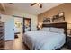 Bedroom with stylish barn door entrance to the primary bath, tiled floors, and dark wood furnishings at 2801 N Litchfield Rd # 65, Goodyear, AZ 85395