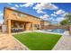 Lush backyard featuring a well-maintained lawn, inviting patio furniture, and a serene outdoor dining area at 2986 E Country Shadows St, Gilbert, AZ 85298