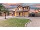 Beautifully landscaped home with well-manicured front lawn and inviting curb appeal at twilight at 2986 E Country Shadows St, Gilbert, AZ 85298