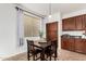 Charming dining area with dark wood furniture, complemented by kitchen cabinetry and natural lighting at 2986 E Country Shadows St, Gilbert, AZ 85298