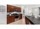 Kitchen featuring stainless steel appliances, dark wood cabinets, granite countertops, and tile flooring at 2986 E Country Shadows St, Gilbert, AZ 85298