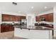 Well-lit kitchen featuring dark wood cabinetry, granite countertops, stainless steel appliances, and a central island at 2986 E Country Shadows St, Gilbert, AZ 85298