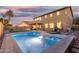 Stunning backyard oasis with a sparkling pool, lounge chairs, palm tree, and covered patio; perfect for relaxation at 2986 E Country Shadows St, Gilbert, AZ 85298