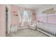 Charming pink Bedroom with personalized decor, a white crib, a comfortable rocker, and soft lighting at 3103 S Benton --, Mesa, AZ 85212
