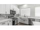 Bright kitchen features white cabinetry, stainless appliances, marble counters, and a farmhouse sink at 3103 S Benton --, Mesa, AZ 85212