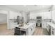 Open kitchen features white cabinets, stainless appliances, marble counters, and center island with seating at 3103 S Benton --, Mesa, AZ 85212