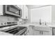 Close up of bright kitchen features white cabinetry, stainless appliances, marble counters, and a farmhouse sink at 3103 S Benton --, Mesa, AZ 85212