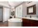 Elegant bathroom boasting a soaking tub, dual vanities, and natural light from plantation shutters at 3441 S Halsted Pl, Chandler, AZ 85286