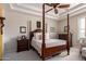 Serene bedroom showcasing a four-poster bed, tray ceilings, and a ceiling fan for added comfort at 3441 S Halsted Pl, Chandler, AZ 85286