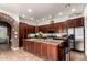 Well-lit kitchen featuring stainless steel appliances, granite countertops, and an island with dark wood cabinets at 3441 S Halsted Pl, Chandler, AZ 85286
