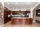 Spacious kitchen featuring dark wood cabinets, tile floors, and granite countertops on a large island at 3441 S Halsted Pl, Chandler, AZ 85286