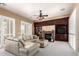 Inviting living room featuring a stone fireplace, custom built-ins, and large windows with plantation shutters at 3441 S Halsted Pl, Chandler, AZ 85286
