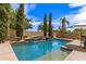 Inviting backyard pool with waterfall feature, stone accents, and lush landscaping creating a private oasis at 3441 S Halsted Pl, Chandler, AZ 85286