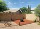An outdoor fire pit area in backyard has gravel and privacy wall at 3555 E Feather Ave, Gilbert, AZ 85234