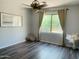 Cozy bedroom featuring wood-look flooring, neutral paint, and a well-lit window at 3555 E Feather Ave, Gilbert, AZ 85234