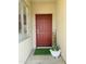 Inviting front entry featuring a deep red door, modern keypad lock, and decorative plant at 3555 E Feather Ave, Gilbert, AZ 85234