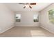 Well-lit bedroom with plush carpeting, modern ceiling fan, and scenic views from the generously sized windows at 3750 S Ashley Pl, Chandler, AZ 85286