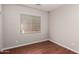 Cozy bedroom with hardwood floors, neutral paint, and large window with blinds at 3750 S Ashley Pl, Chandler, AZ 85286
