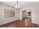 Elegant dining room featuring a classic chandelier, wood floors, and bright window at 3750 S Ashley Pl, Chandler, AZ 85286