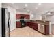 Open kitchen features dark wood cabinets, stainless appliances, and tile flooring at 3750 S Ashley Pl, Chandler, AZ 85286