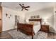 Cozy bedroom with wood flooring, ceiling fan, large bed, and bright natural light at 3930 E Colonial Dr, Chandler, AZ 85249
