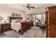 Bright bedroom with a ceiling fan, a chair near the window, and wood flooring at 3930 E Colonial Dr, Chandler, AZ 85249