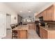 Open kitchen featuring wood cabinets, granite countertops, tile flooring, and breakfast bar seating at 3930 E Colonial Dr, Chandler, AZ 85249