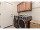Laundry room featuring side-by-side washer and dryer, overhead cabinets and tile flooring at 3930 E Colonial Dr, Chandler, AZ 85249