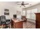 Well-lit office featuring wood floors, a ceiling fan, a large desk, and a comfortable armchair at 3930 E Colonial Dr, Chandler, AZ 85249