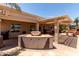 Outdoor kitchen with built in grill, bar, seating, pergola and desert landscaping at 3930 E Colonial Dr, Chandler, AZ 85249