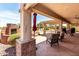 Covered outdoor patio with stone flooring, fireplace, ceiling fans, outdoor furniture and golf course views at 3930 E Colonial Dr, Chandler, AZ 85249