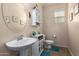 Charming powder room with a pedestal sink, decorative cabinet, and cozy blue rugs at 3960 W Salter Dr, Glendale, AZ 85308