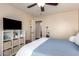 Bright bedroom with an organized storage unit and a comfortable bed, illuminated by a ceiling fan at 3960 W Salter Dr, Glendale, AZ 85308