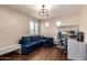 Bright living room featuring a comfortable blue couch, work desk, and a modern ceiling fan for a relaxing and functional space at 3960 W Salter Dr, Glendale, AZ 85308