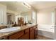 Serene primary bathroom featuring double sinks, wood cabinets, and a soaking tub at 3960 W Salter Dr, Glendale, AZ 85308