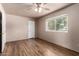Bright bedroom with ceiling fan, neutral paint, and a large window with a view of the yard at 4420 E Covina St, Mesa, AZ 85205