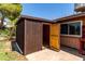 Exterior shot of backyard shed with a wood door, offering extra storage at 4420 E Covina St, Mesa, AZ 85205