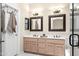 Well-lit bathroom with double sink vanity, framed mirrors, updated fixtures, and a door to the water closet at 4748 E Eden Dr, Cave Creek, AZ 85331