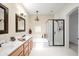 Bright bathroom features a double sink vanity, framed mirrors, a large soaking tub, and a glass shower at 4748 E Eden Dr, Cave Creek, AZ 85331