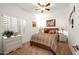 Cozy bedroom with a patterned bedspread, dresser, bedside tables, and a window with plantation shutters at 4748 E Eden Dr, Cave Creek, AZ 85331