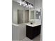 Stylish bathroom vanity with modern lighting, marble countertop, dark cabinets, and tile flooring at 525 N Miller Rd # 239, Scottsdale, AZ 85257