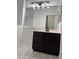 Modern bathroom vanity area featuring a dark cabinet, marble countertop, and rectangular lighting fixture at 525 N Miller Rd # 239, Scottsdale, AZ 85257
