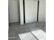 Bedroom featuring tile floors, sliding closet doors, and two additional doors at 525 N Miller Rd # 239, Scottsdale, AZ 85257