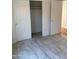Bright bedroom features wood look flooring and closet with bifold doors at 525 N Miller Rd # 239, Scottsdale, AZ 85257