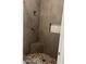Tiled shower stall featuring a corner seat, built in shelf, and pebble floor at 525 N Miller Rd # 239, Scottsdale, AZ 85257
