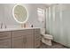 Bathroom with a round lighted mirror, gray vanity, and a shower/tub with curtain at 652 E Rojo Way, Gilbert, AZ 85297