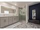 This primary bathroom showcases double sinks, decorative tile floors, and a glass-enclosed shower at 652 E Rojo Way, Gilbert, AZ 85297