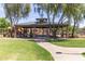 Community pavilion with picnic tables surrounded by trees, playground, and grassy areas at 652 E Rojo Way, Gilbert, AZ 85297
